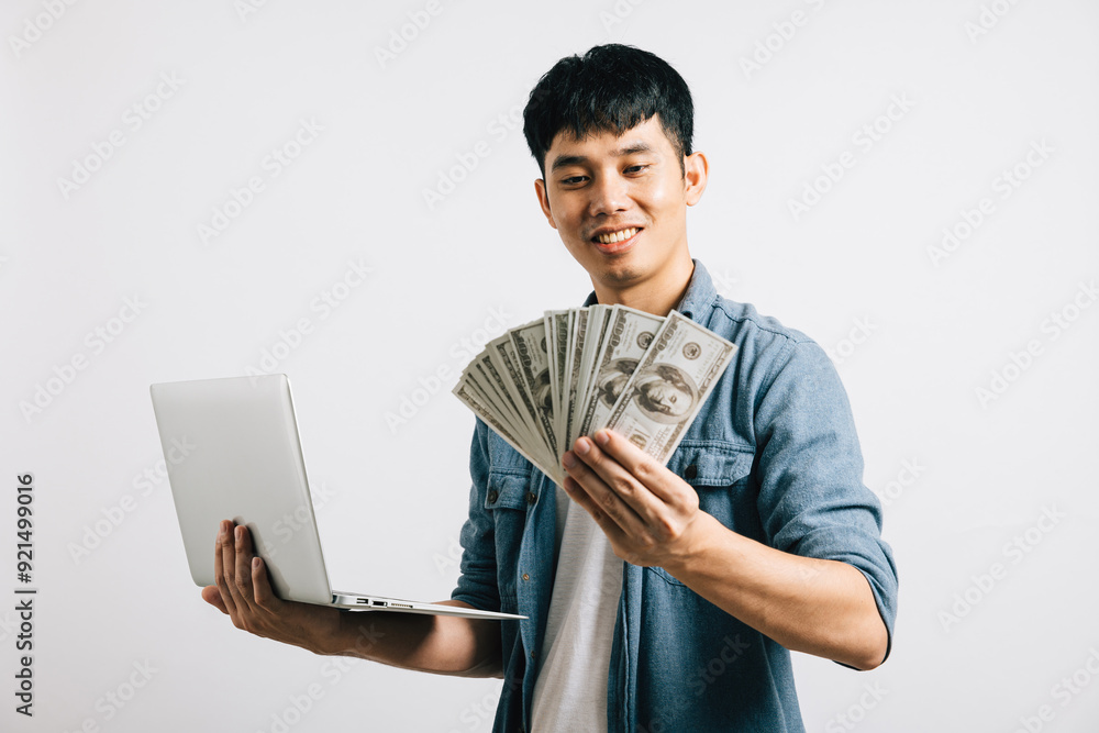 Portrait Asian smiling young man holding laptop computer and fan of money cash studio shot isolated white background, Happy excited lifestyle businessman hold money in dollar banknotes Portrait Asian smiling young man holding laptop computer and fan of money cash studio shot isolated white background, Happy excited lifestyle businessman hold money in dollar banknotes