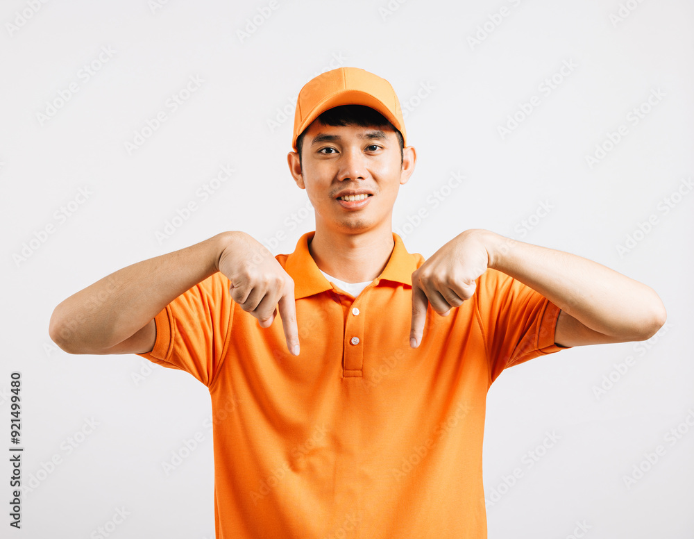 Portrait Asian smiling young delivery man pointing down something with empty space hands studio isolated white background, Happy lifestyle men carry person in an orange shirt uniform point finger Portrait Asian smiling young delivery man pointing down something with empty space hands studio isolated white background, Happy lifestyle men carry person in an orange shirt uniform point finger