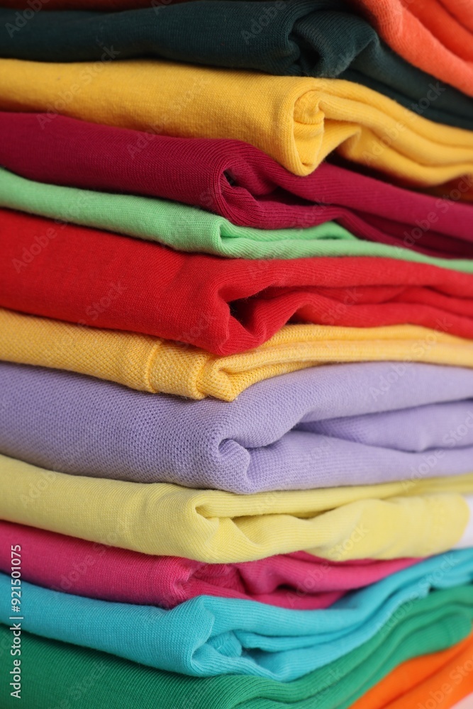 Stack of clean colorful t-shirts as background, closeup Stack of clean colorful t-shirts as background, closeup
