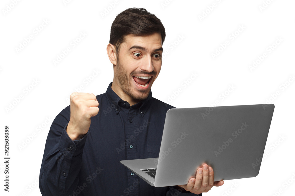 Excited young businessman in blue shirt looking at laptop as a winner Excited young businessman in blue shirt looking at laptop as a winner