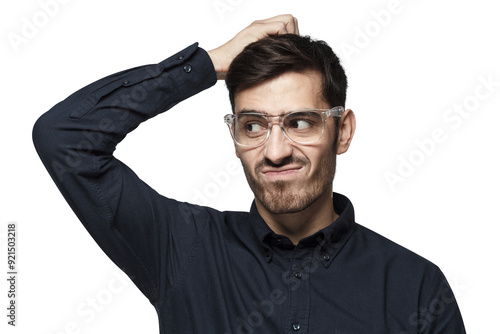 Young thoughtful businessman thinking, scratching his head trying to find solution