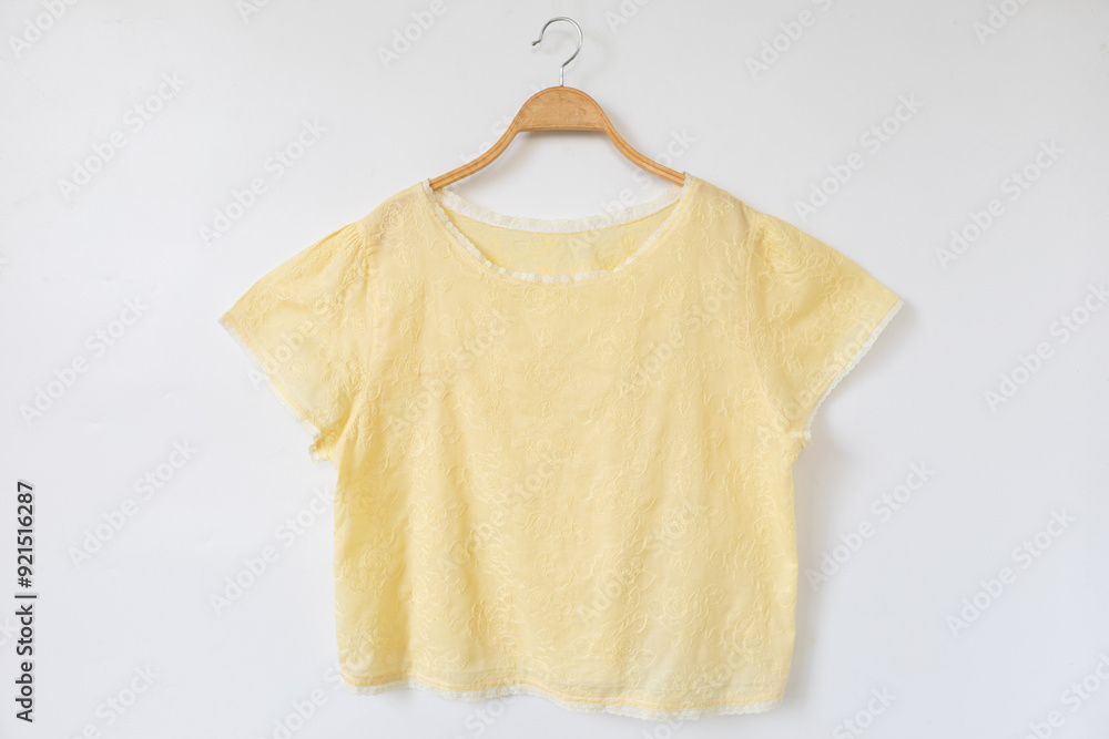 Yellow blouse on a hanger.