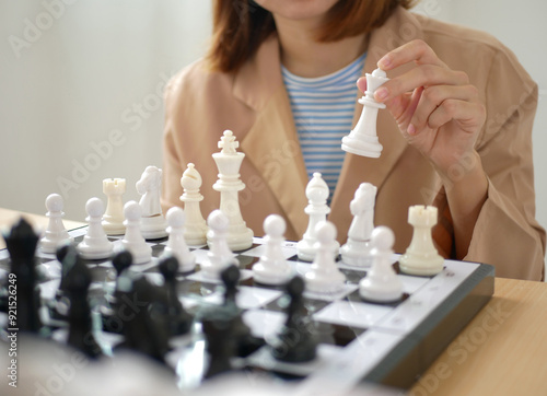 Asian businesswoman playing chess business concept.and plot the market probabilities using chess to work photo