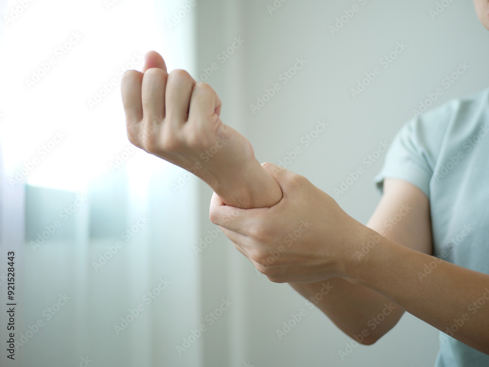 Obraz premium A young businesswoman suffered a wrist injury, numbness and pain from working too long. Health care and office syndrome concept.