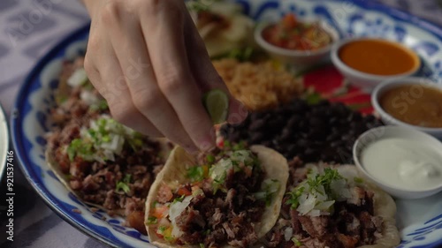 Hand sqeeze lime in to beef Mexican soft taco food 4k photo