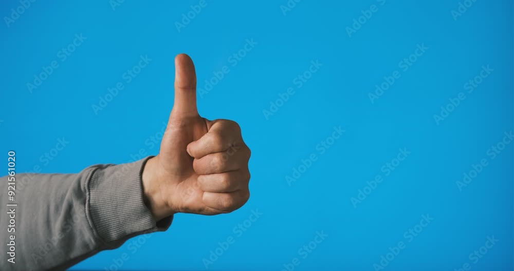 A hand shows a thumbs up gesture, signaling approval, with a bright blue background enhancing the message of positivity. A hand shows a thumbs up gesture, signaling approval, with a bright blue background enhancing the message of positivity.