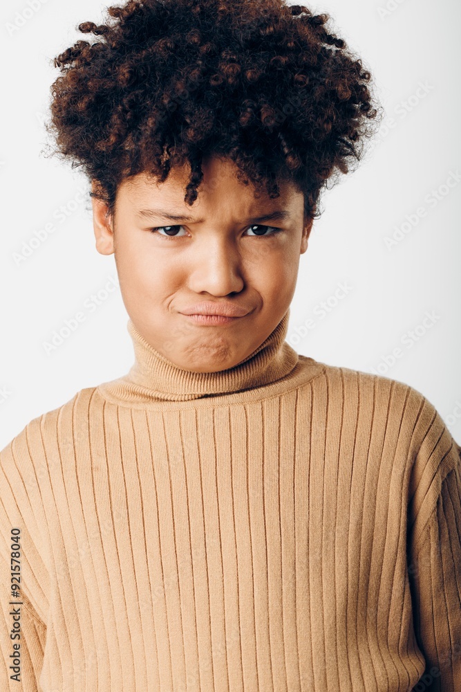 confident young boy with afro wearing turtle neck sweater gaze intently at camera under soft natural light