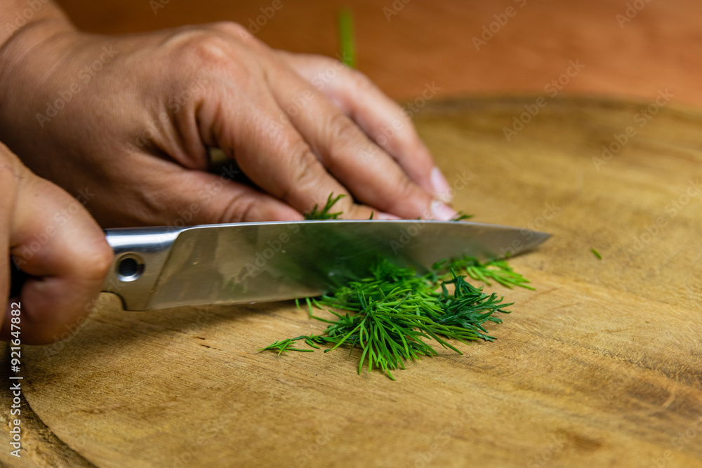 Woman cutting green dill on the cutting board Woman cutting green dill on the cutting board