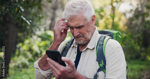 Photos Thinking, phone and mature man in nature for directions, navigation app and checking route