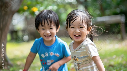 two happy asian children having good time playing in city park