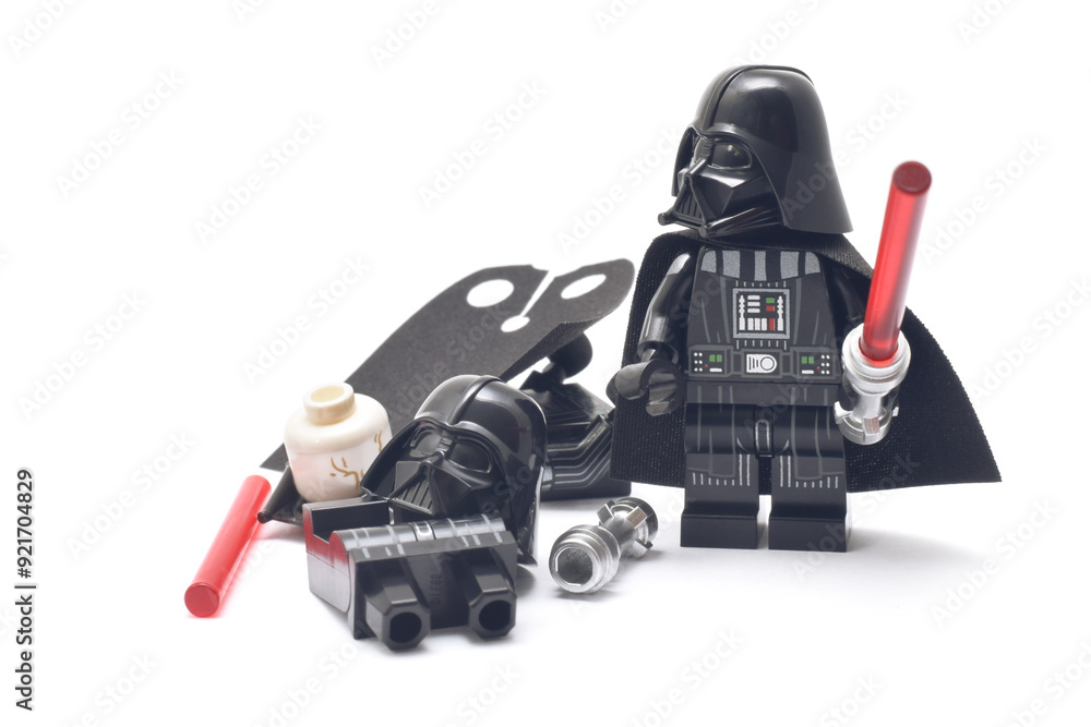 Naklejka premium Lego minifigure of Darth Vader of Star Wars with red lightning sword isolated on white. Editorial illustrative image of popular plastic constructor and 25 Anniversary