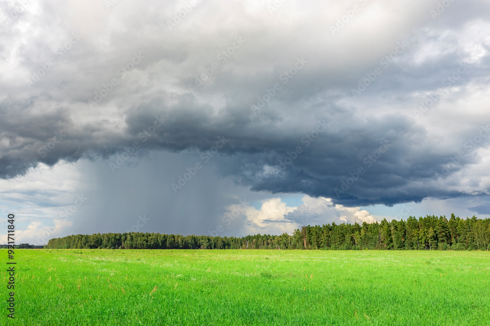 A storm is brewing in the sky over a field of grass A storm is brewing in the sky over a field of grass