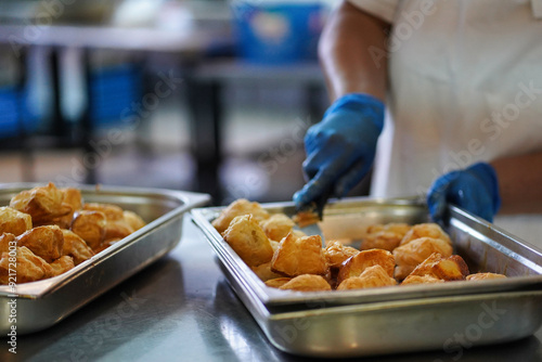 A female cook prepares traditional Bulgarian pasta snacks called cheese pie - banitsa