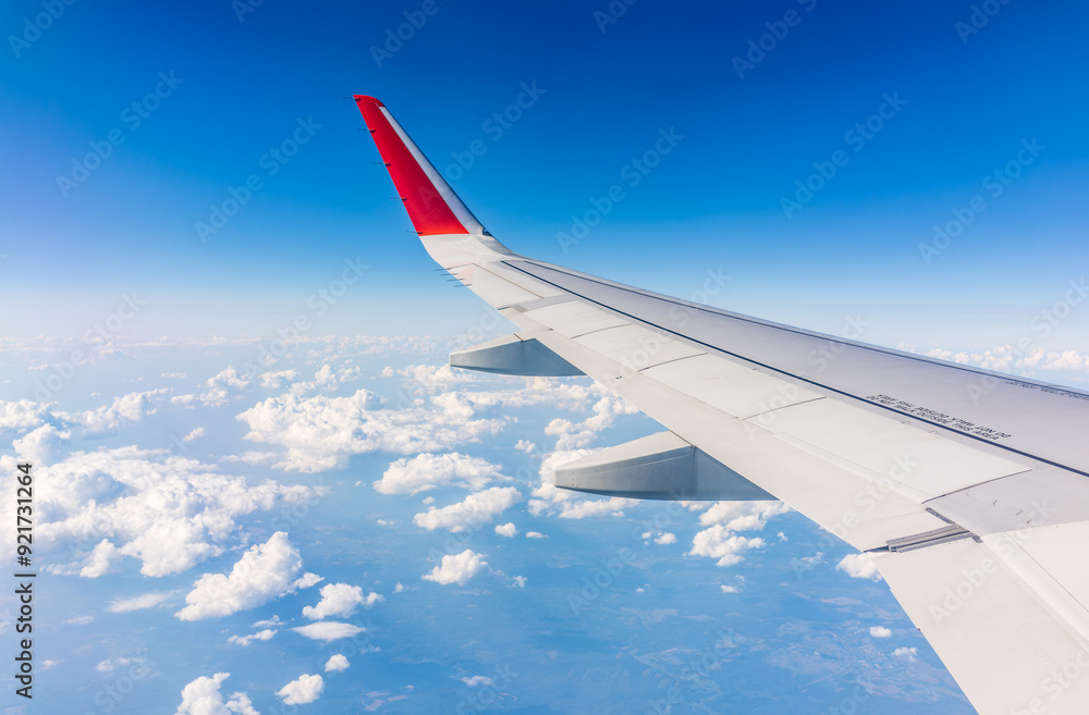 Fototapeta premium View from the airplane window at a beautiful cloudy sky and the airplane wing