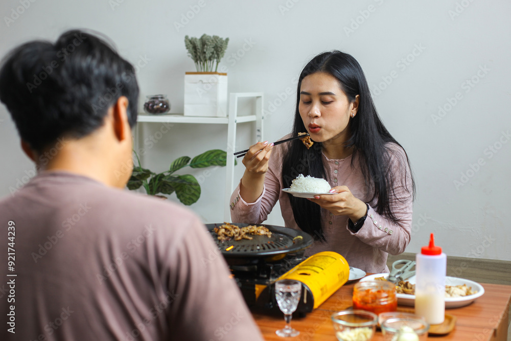 Young Asian Man And Woman Eating Korean Barbaque Grill Together Young Asian Man And Woman Eating Korean Barbaque Grill Together