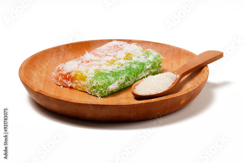 Sentiling, or Lapis Singkong, is a sweet Indonesian snack made from cassava, colored red, yellow, and green. Served with grated coconut or sugar. Photographed on a white background. photo