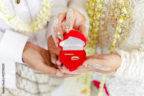 Close up of bride's hands holding ring box. Indonesian bride with white kebaya dress and jasmine necklace