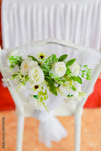 White bridal chair decorated with flower arrangement. Selective focus