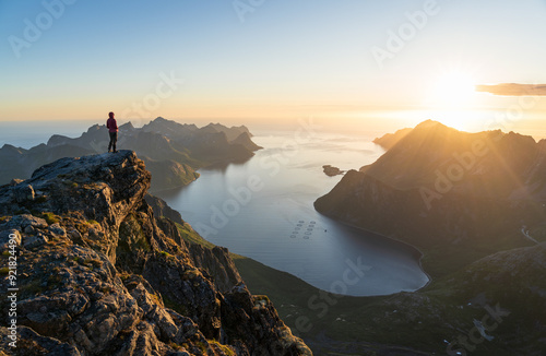 Obraz na płótnie A woman enjoying the view and the midnightsun on the summit of Keipen, Senja. w salonie