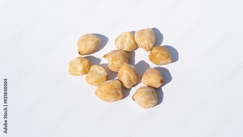 Candlenut Seeds, Casting Shadows on a White Surface, Emphasizing Their Organic Form Candlenut Seeds, Casting Shadows on a White Surface, Emphasizing Their Organic Form