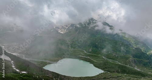 Susten Pass with Steinsee Lake in background, Swiss Alps. Aerial drone flying through clouds photo