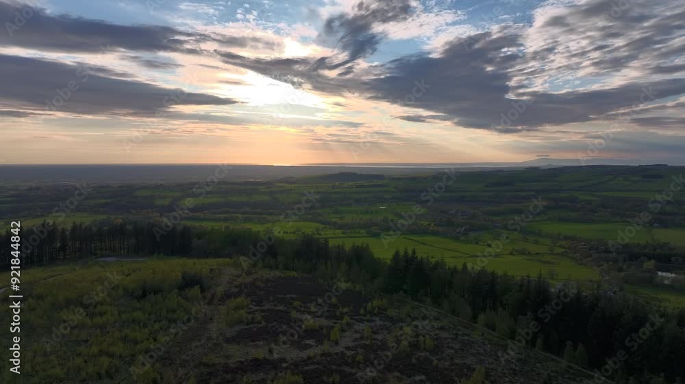 Flying over forested fell towards setting sun over English countryside at golden hour. Beacon Fell, Lancashire, UK Flying over forested fell towards setting sun over English countryside at golden hour. Beacon Fell, Lancashire, UK