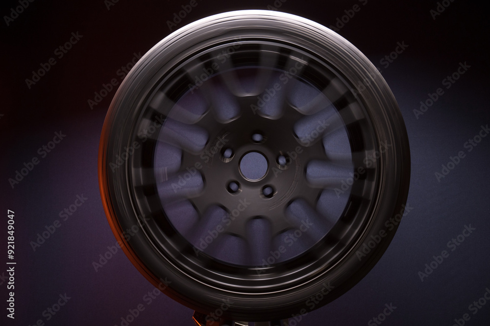 sports matte black car rims illuminated by blue light, long exposure photography for motion blur effect while spinning sports matte black car rims illuminated by blue light, long exposure photography for motion blur effect while spinning