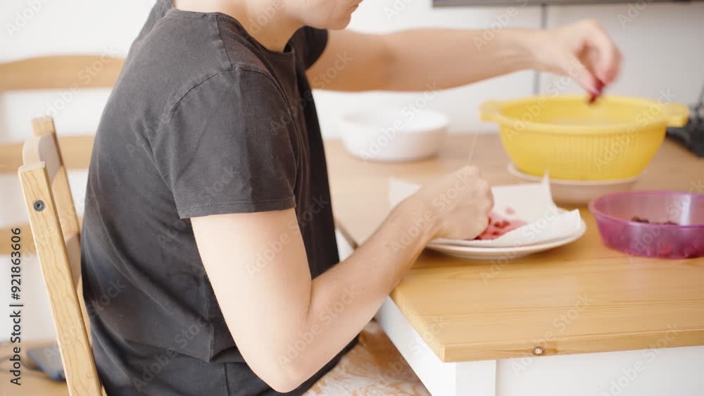 Cherry Perfection, woman expertly cuts and pits cherries. The scene captures the meticulous process of preparing cherries for optimal enjoyment. Cherry Perfection, woman expertly cuts and pits cherries. The scene captures the meticulous process of preparing cherries for optimal enjoyment.