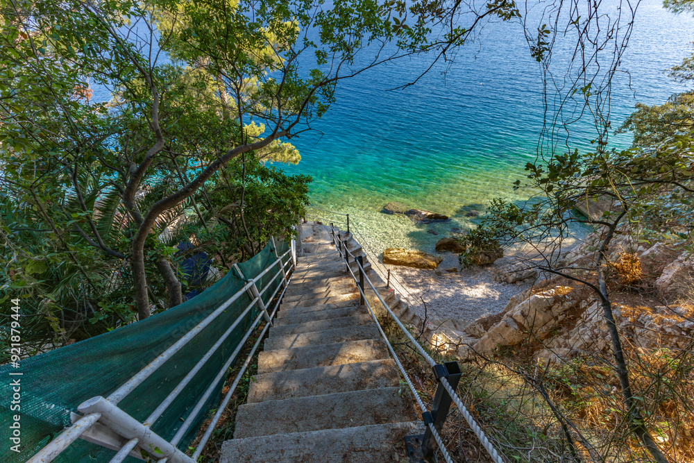 Fototapeta premium Dangerous descent down steep stairs to a small beach
