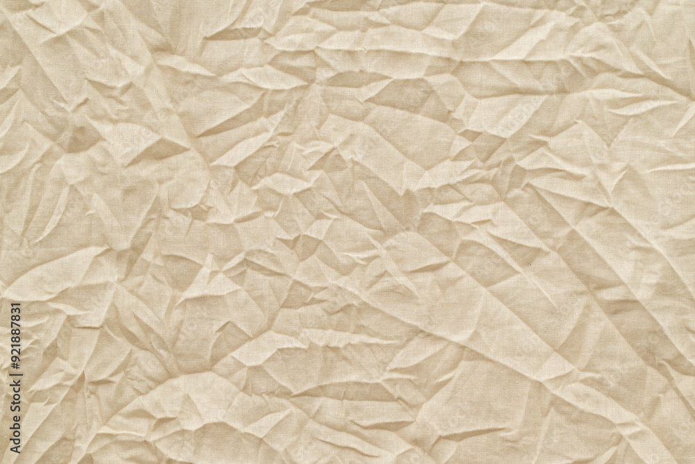 Fototapeta premium Old textile, crumpled texture, surface for background. Pale brown recycled battered kraft material, copy space for text