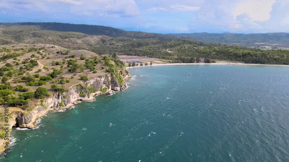 A beach flanked by cliffs, featuring vibrant blue waters and soothing waves A beach flanked by cliffs, featuring vibrant blue waters and soothing waves