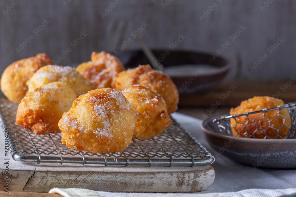 Curd donuts with sugar served with tea or coffee on a light wooden background. Rustic style.