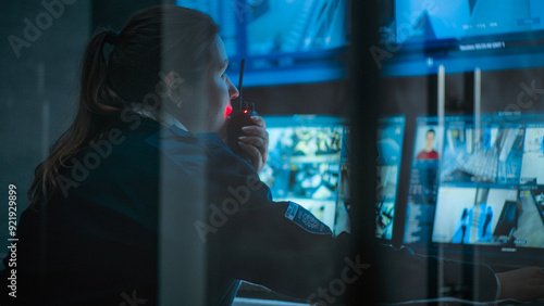 фотографія Close up of female CCTV operator working on computer in monitoring center with security cameras, talking on walkie talkie