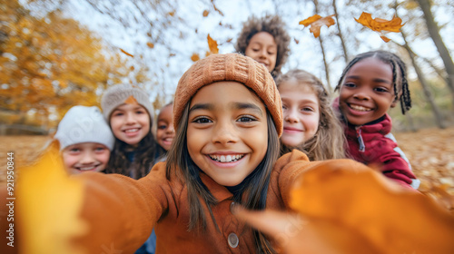 Happy diverse group of friends, cute young kids or teenage boys and girls with cheerful, joyful facial expressions taking a selfie or photo in an autumn forest or park, happiness and diversity