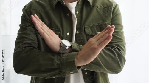 STOP hand gesture
The guy shows a denial gesture with his hands.
No, stop.