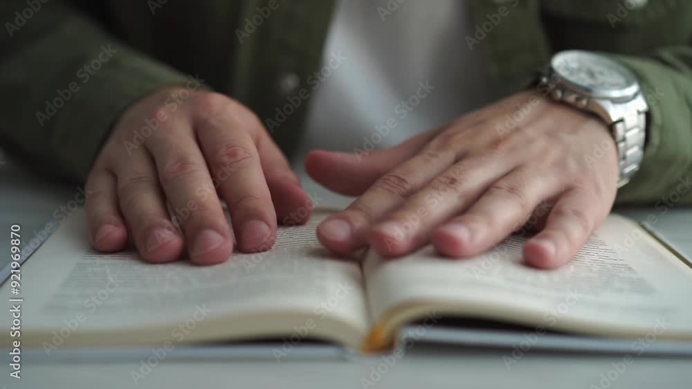 reading books. Side view book close up on the table. man exits through book page and reads text in library reading books. Side view book close up on the table. man exits through book page and reads text in library