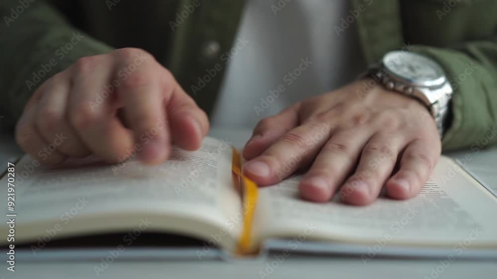 reading books. Side view book close up on the table. man exits through book page and reads text in library reading books. Side view book close up on the table. man exits through book page and reads text in library