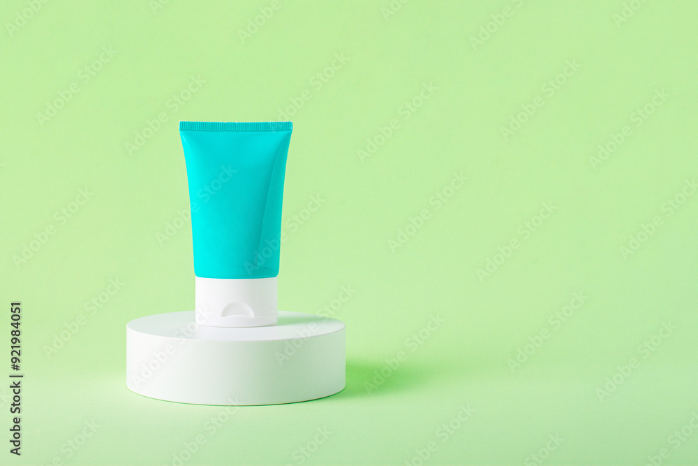 Blue cosmetic bottle, Skin care or sunscreen cosmetic with stylish props on green background. Blue cosmetic bottle, Skin care or sunscreen cosmetic with stylish props on green background.