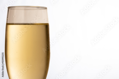 A close-up of a champagne glass filled with champagne on a white backdrop, symbolizing the joy of holiday celebrations like Christmas and New Year's Eve. photo