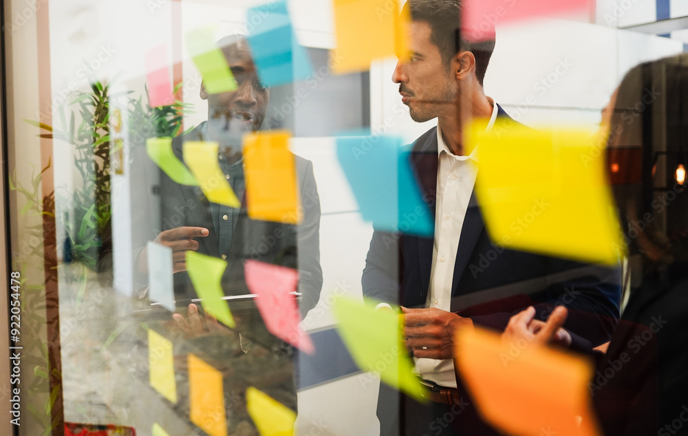 Multiracial colleagues working inside business office with glass walls - Entrepreneurs people sharing ideas at teamwork meeting - Brainstorming concept - Main focus on center man face Multiracial colleagues working inside business office with glass walls - Entrepreneurs people sharing ideas at teamwork meeting - Brainstorming concept - Main focus on center man face