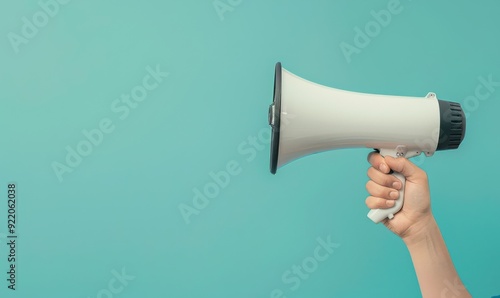 Hand holding a megaphone, ready for an important announcement on a blue background. Free copy space for text.