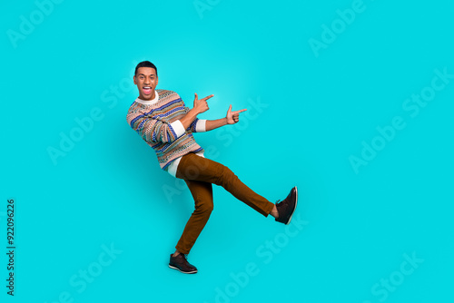 Full size photo of nice young man point fingers empty space wear sweater isolated on teal color background