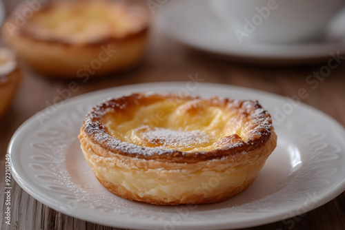 Traditional Portuguese Queijada with espresso on rustic wooden table. Perfectly baked and inviting.