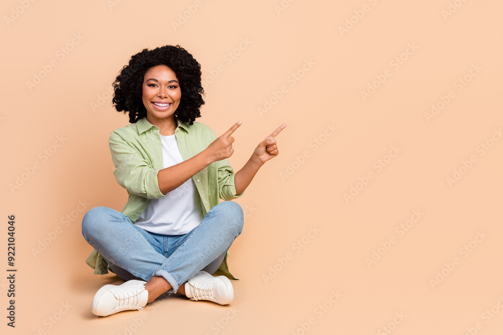 Full length portrait of pretty young woman direct fingers empty space wear shirt isolated on beige color background Full length portrait of pretty young woman direct fingers empty space wear shirt isolated on beige color background