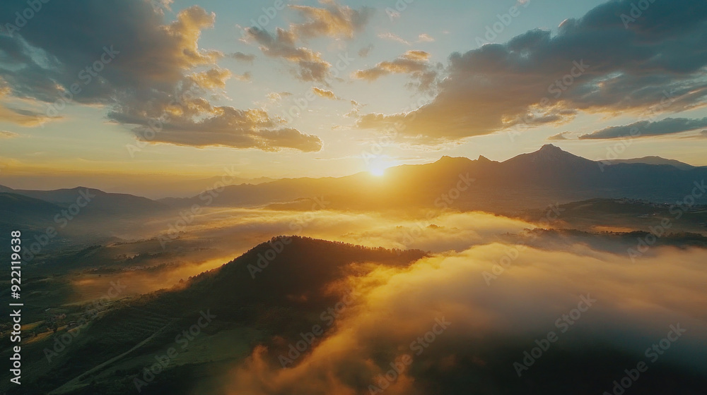 Obraz premium Golden sunlight paints vibrant hues across a breathtaking mountain cloudscape