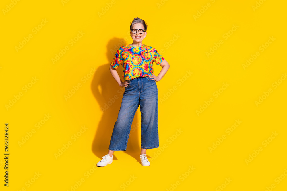 Fototapeta premium Photo of cheerful glad senior woman wear stylish print clothes empty space isolated on vivid yellow color background