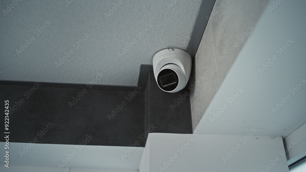Close up shot of installed CCTV camera hanging on the ceiling in the room of the office building. Modern monitoring and tracking technologies. Security system, video surveillance and privacy concept. Close up shot of installed CCTV camera hanging on the ceiling in the room of the office building. Modern monitoring and tracking technologies. Security system, video surveillance and privacy concept.