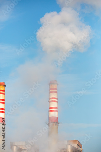 Industrial smoke from chimney on blue sky