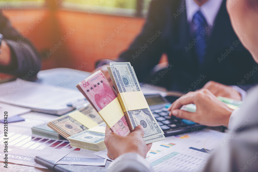 Fototapeta premium Businesswoman holding money banknotes and making decision for business investment. Selected focus 