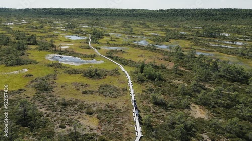 Aerial images over the bog in Estonia, The incredible biodiversity of this country is astounding, providing us with amazing landscapes. a group of persons are walking on the wooden walk path